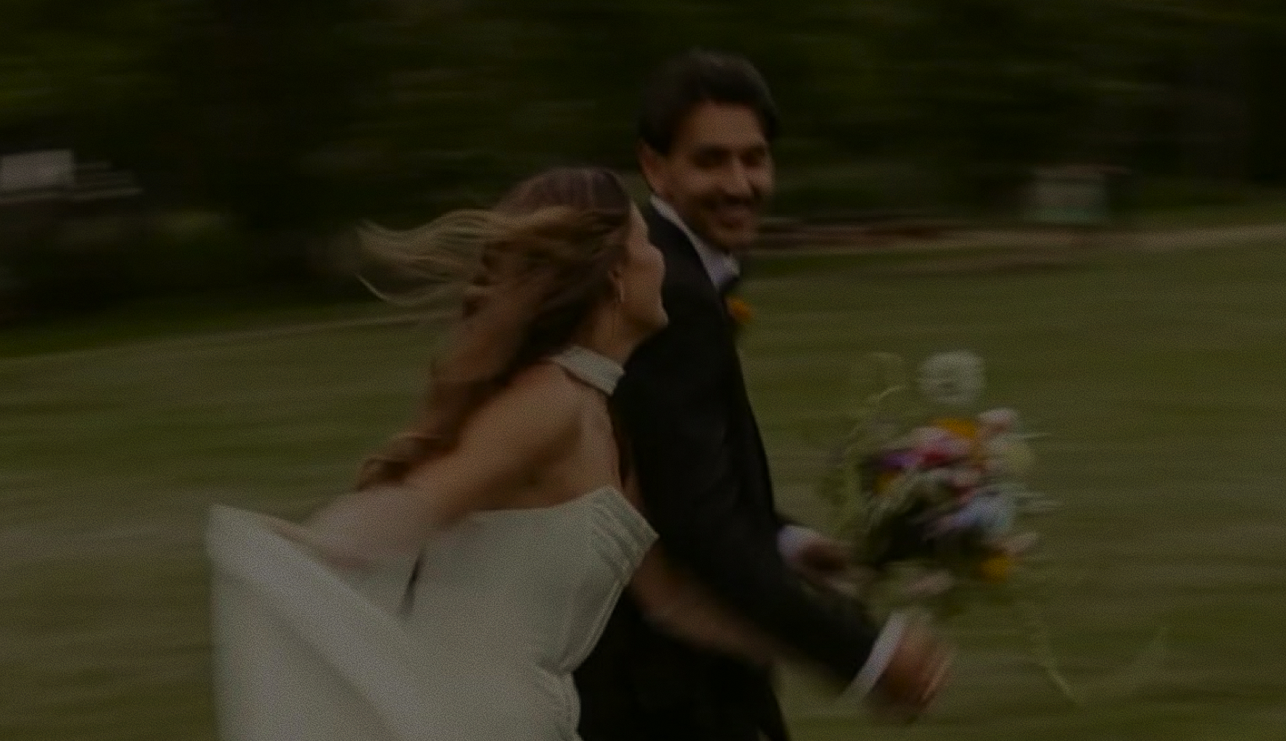 Couple running through a field on their wedding day
